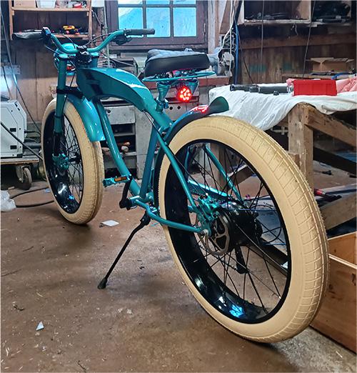 Beach cruiser bleu et noir dans un atelier